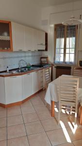 a kitchen with white cabinets and a table and chairs at Casa Vanda in Orte