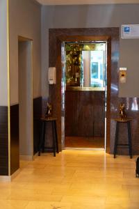 a room with a door with a mirror and two tables at Hotel Mondial Munich in Munich