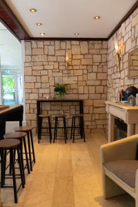 a restaurant with a stone wall with a table and stools at Hotel Mondial Munich in Munich