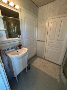 a white bathroom with a sink and a mirror at Bockekulla Gård in Bergkvara +18 photos