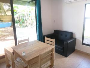 a living room with a table and a chair and a couch at Casa Debut Surf Place 2 in Parrita +20 photos