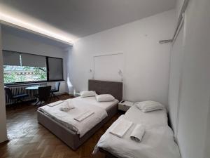 dwa łóżka w pokoju ze stołem i oknem w obiekcie Iancu Apartments w Bukareszcie