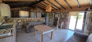 a kitchen and living room with a table and a stove at Borak's Stone Village in Rizokarpaso