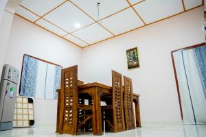 a dining room with a table and two windows at Naga Vasa in Jaffna +1 photo