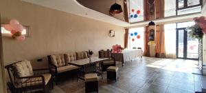 a room with a table and chairs and a table and a room with balloons at Nino in Kaspi