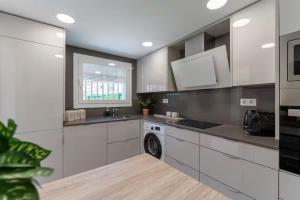 a white kitchen with a sink and a dishwasher at CASA AZUL Blanes in Blanes
