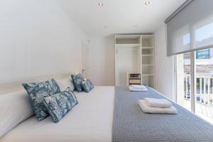 a bedroom with a large bed with blue pillows at CASA AZUL Blanes in Blanes