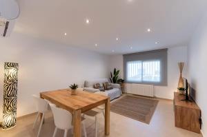 a living room with a table and a couch at CASA AZUL Blanes in Blanes
