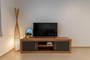 a flat screen tv sitting on top of a wooden entertainment center at CASA AZUL Blanes in Blanes