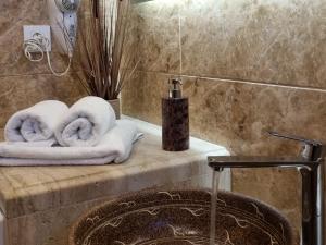 a bathroom with two rolled towels on a counter at Marathon Studios & Apartments in Keri