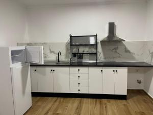 a kitchen with white cabinets and a microwave at Aria Apartments in Borsh