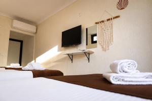 a hotel room with two beds and a flat screen tv at Kent Pansiyon Ayvalık in Ayvalık