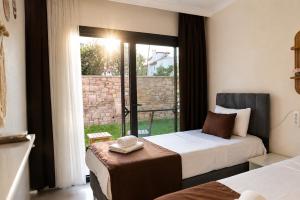 a hotel room with two beds and a window at Kent Pansiyon Ayvalık in Ayvalık
