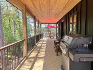 a screened porch with a bbq and a grill at Towering Pines Cottage in Saint Germain