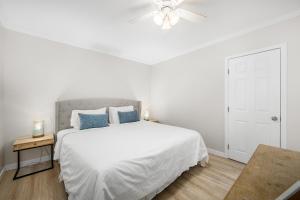 a white bedroom with a bed and a ceiling fan at 1628 West Oceanfront Oasis 6 in Newport Beach