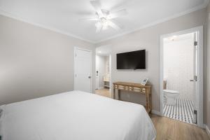 a white bedroom with a bed and a ceiling fan at 1628 West Oceanfront Oasis 6 in Newport Beach