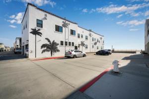 a white fire hydrant in a parking lot next to a building at 1628 West Oceanfront Oasis 6 in Newport Beach