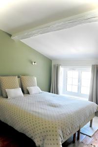 a bedroom with a white bed with a window at Gite La Saintonge in Sainte-Gemme