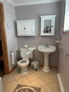 a bathroom with a toilet and a sink at Loft de la mer in Sainte-Flavie +35 photos