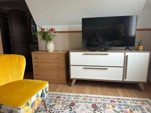a living room with a white dresser with a tv on it at Loft de la mer in Sainte-Flavie