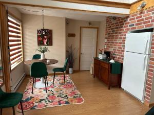 a kitchen with a table and chairs and a refrigerator at Loft de la mer in Sainte-Flavie