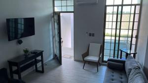 a living room with a couch and a chair and a television at Casa o departamento hermoso CHARLY in Tuxpan de Rodríguez Cano