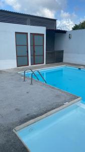 a blue swimming pool in front of a building at Casa o departamento hermoso CHARLY in Tuxpan de Rodríguez Cano