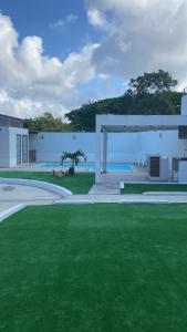 a large yard with green grass and a building at Casa o departamento hermoso CHARLY in Tuxpan de Rodríguez Cano