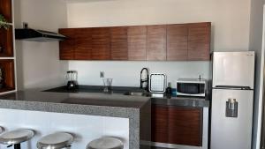 a kitchen with wooden cabinets and a counter top at Casa o departamento hermoso CHARLY in Tuxpan de Rodríguez Cano