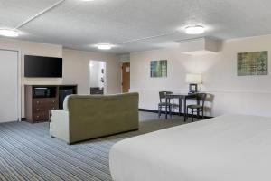 a hotel room with a bed and a table at Best Western Woodhaven Inn in Woodhaven