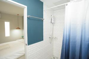 a bathroom with a shower with a blue shower curtain at MINI Plume Minburi in Min Buri +22 photos
