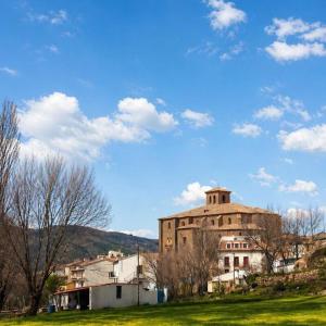 a large building with a hill in the background at Casa rural en Buendía -la Galera con 4 dormitorios in Buendía