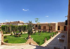 a courtyard with tables and chairs in a building at Happy Oasis Hotel in Siwa