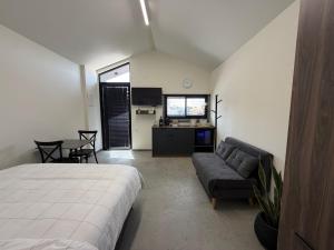 a bedroom with a bed and a couch and a table at טריו בכרמל in Dāliyat el Karmil