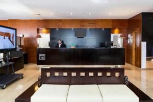 a man sitting at a bar in an office at Sercotel AB Arganda in Arganda del Rey