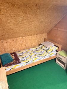 a bed in a room with a wooden wall at Riverside Cabin in Železnička Stanica Ovčar Banja