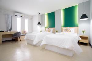 two beds in a room with green and white walls at MINI Plume Minburi in Min Buri