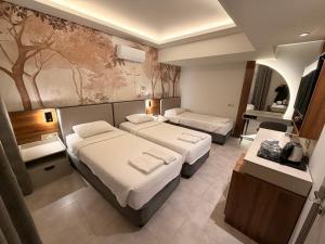 a hotel room with two beds and a desk at Ida Hotel in Marmaris