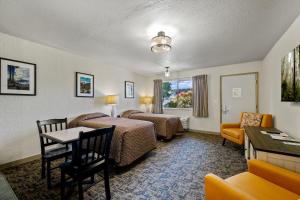 a hotel room with two beds and a table at Cocusa Motel in Burlington