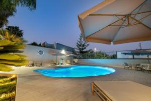 a swimming pool with an umbrella and tables and chairs at HOLIDAYS ALBA in Catania