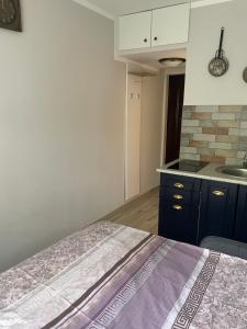 a room with a bed and a kitchen with a sink at Suite4Rent Iași in Iaşi