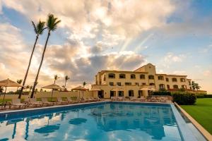 a pool in front of a building with palm trees at Las Villas Hotel & Golf By Estrella del Mar in Mazatlán