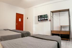 a hotel room with two beds and a mirror at Large Studios 2km from Vila Germanica in Blumenau