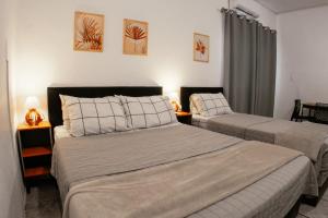 a bedroom with two beds and a room with two lamps at Large Studios 2km from Vila Germanica in Blumenau