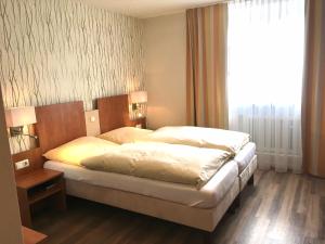 Postel nebo postele na pokoji v ubytování tauwerk Hotel