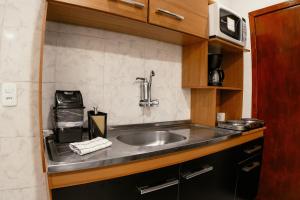 a kitchen counter with a sink and a microwave at Large Studios 2km from Vila Germanica in Blumenau +208 photos