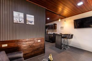 a kitchen with a bar and a tv on a wall at Apartamentos Javi in Tela