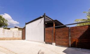a house with a wooden gate and a fence at Apartamentos Javi in Tela +1 photo