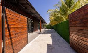 a walkway between two wooden fences with palm trees at Apartamentos Javi in Tela