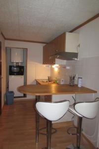 a kitchen with a table and two white stools at studio centre de Gap in Gap +5 photos